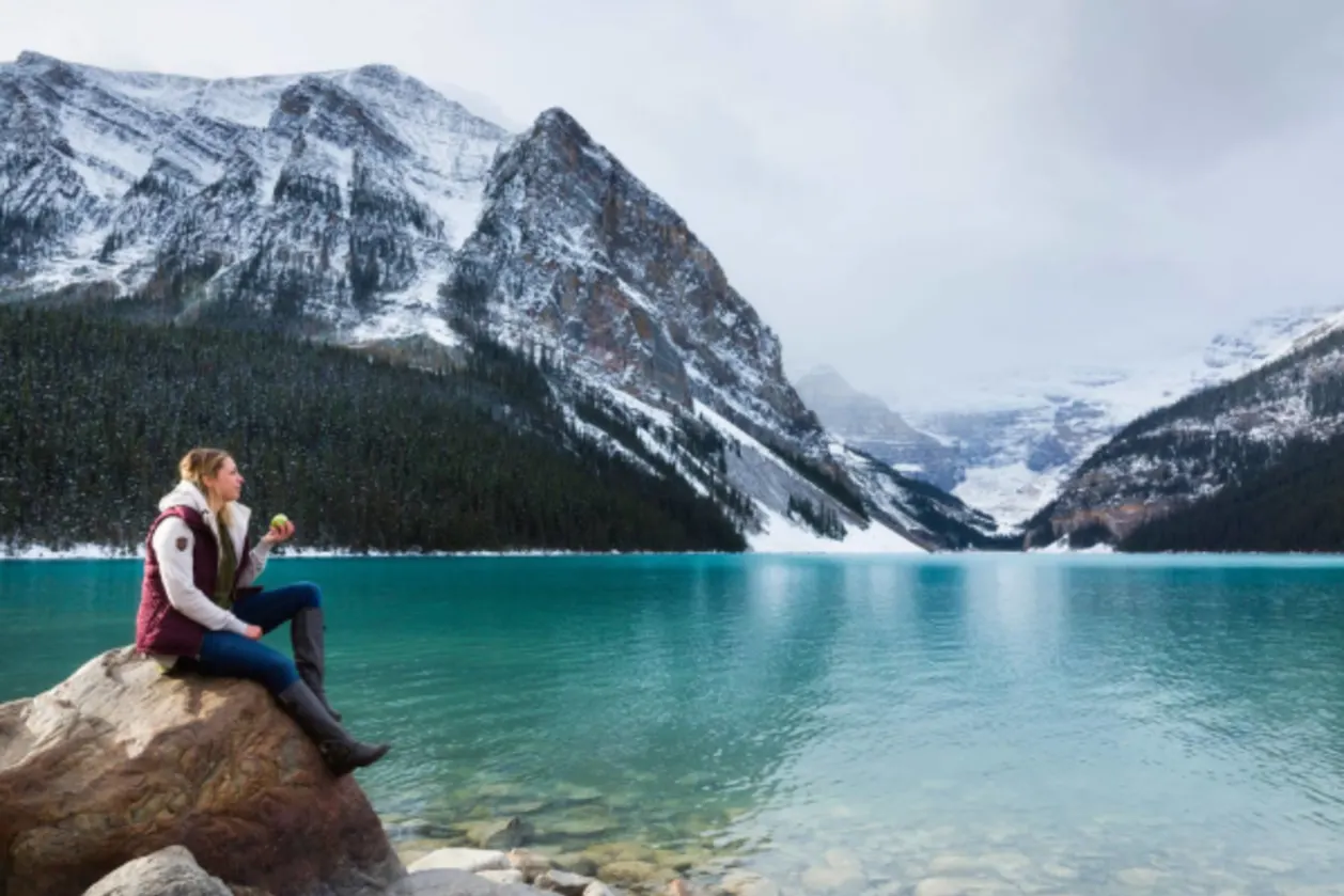 hiker sitting on rock at fairmont lake louise